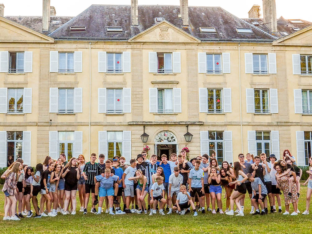 Secondary school student group posing outside Travelbound's exclusive Chateau du Molay in Normandy, France