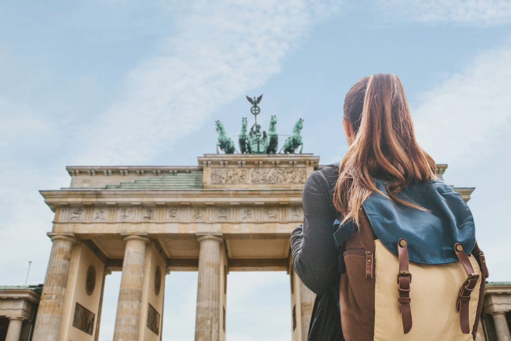 Student girl looking up at the Brandenburg Gate in Berlin, Germany