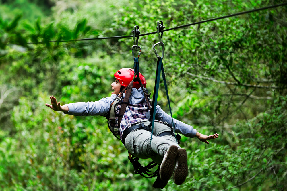 Student wearing a helmet on a zipline